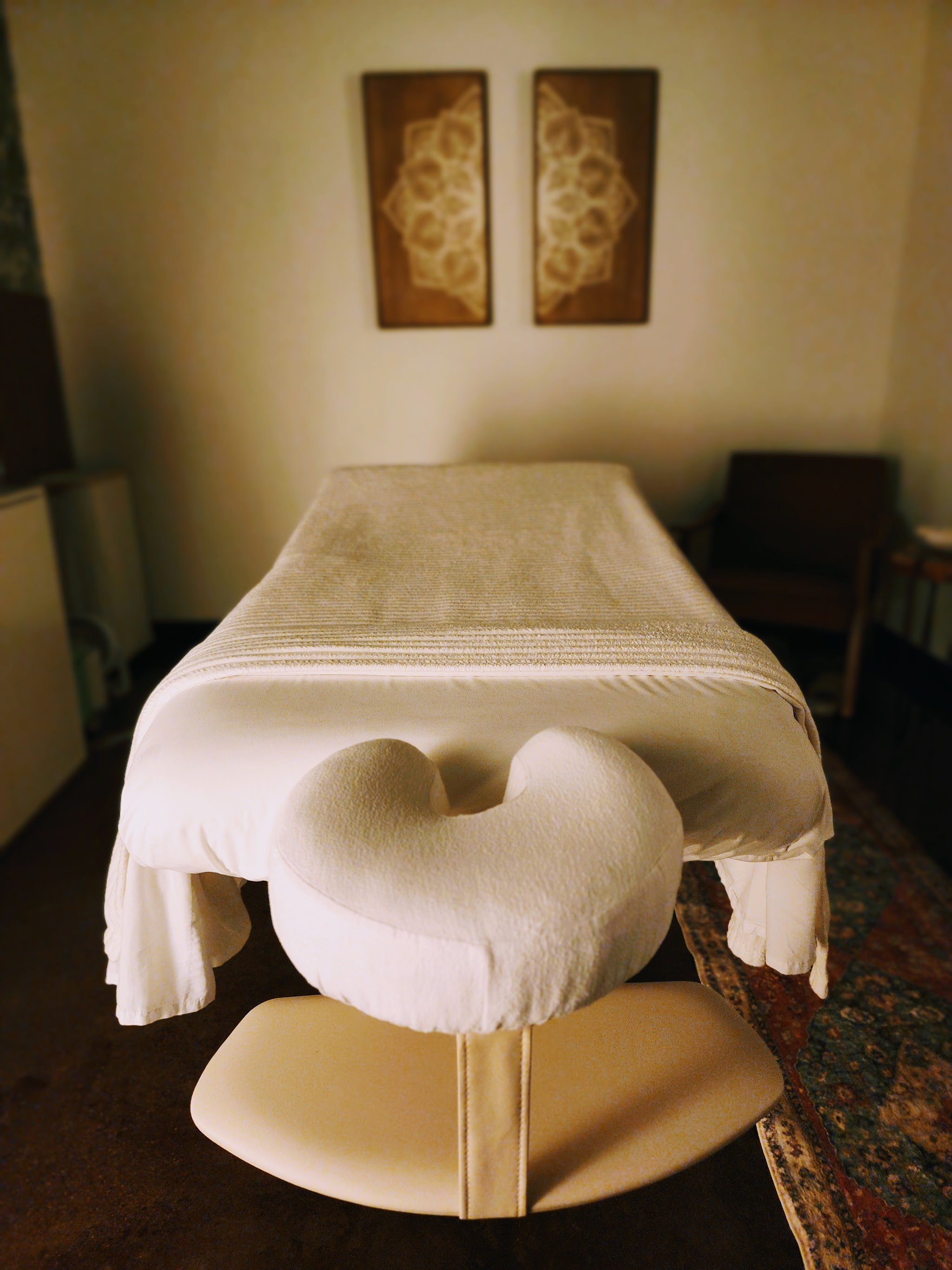 A freshly made massage table with a cushioned face cradle