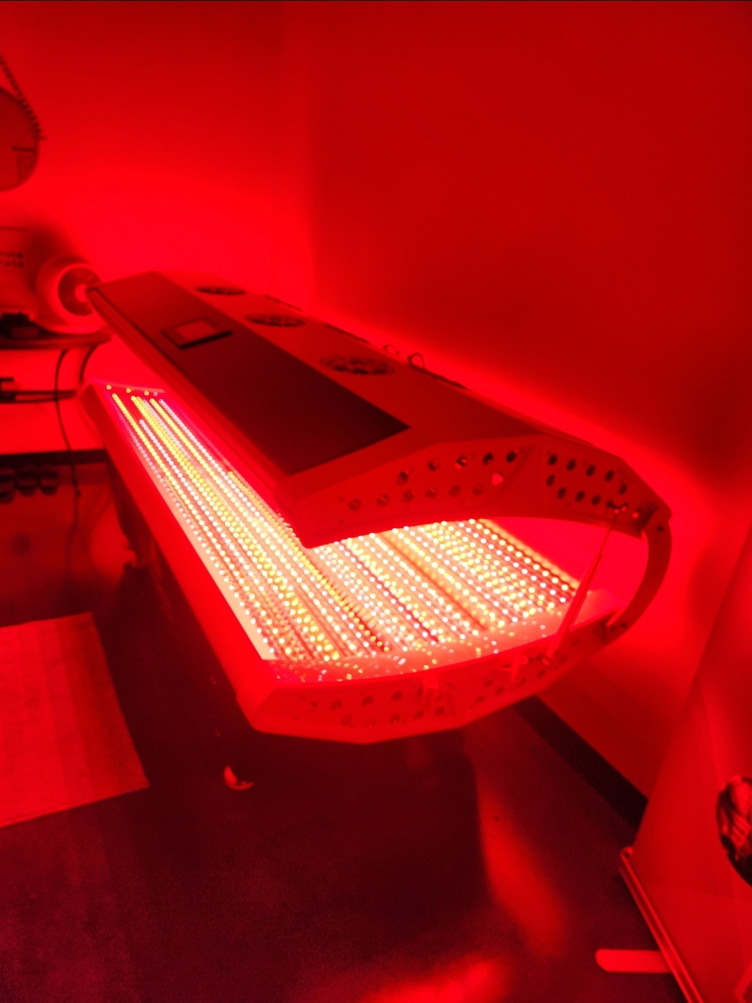 Our red light therapy bed glowing in a darkened room
